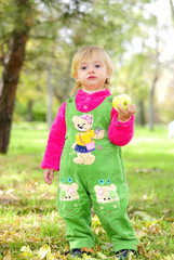 Маленькая девочка на зеленой траве осенью