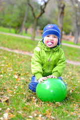 Маленький мальчик с воздушным шариком на поляне