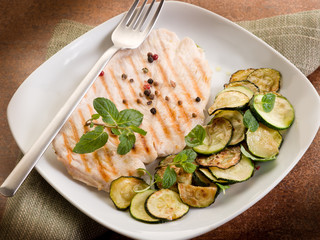 chest of grilled chicken with zucchinis and mint leaf