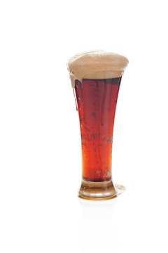 dark beer with the foam in a tall glass isolated on white