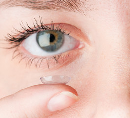 Fototapeta premium Close up of inserting a contact lens in female eye