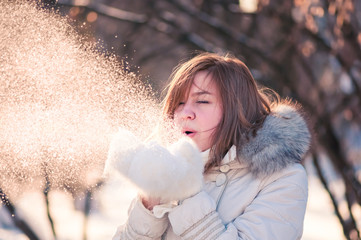 Beautiful woman blowing in the snow