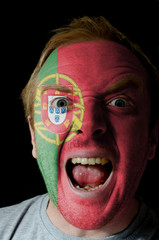 Face of crazy angry man painted in colors of portugal flag