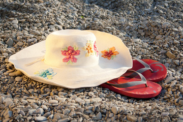 hat and flip-flops on the stones