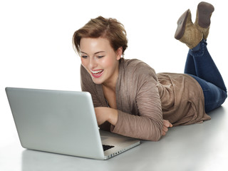 Woman lying on the floor with laptop and surfing on the internet