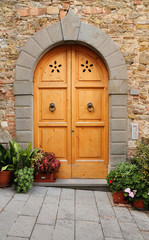 wooden door framed with stone arch in Tuscany