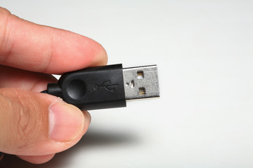 hand holding USB plug , cable isolated.