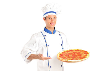A young chef holding a pizza