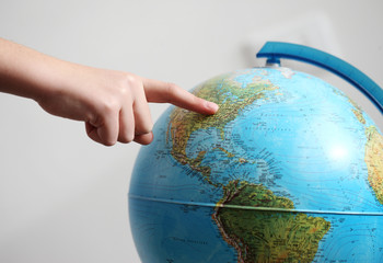 Hand's child  pointing on a globe
