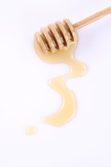 Honey on a honey stick and on a white background