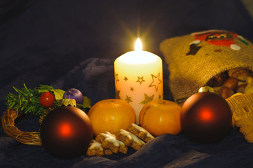 Kerze, Glaskugeln, Mandarinen und Weihnachtskekse