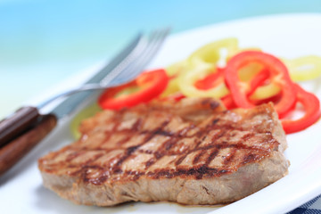 Beef steak with pepper on white plate