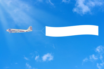 Flying airplane and banner on sky background.