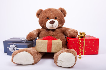 Seated teddy bear with gift boxes