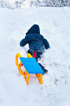 Little Kid Carrying A Sledge Uphill