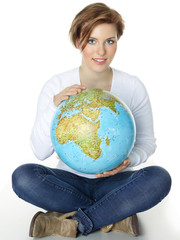 Woman sitting cross-legged on the floor and holding a globe