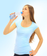 A beautiful young woman to drink the water on a