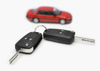 Zündschlüssel mit Auto im Hintergrund