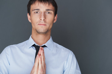 Profile shot of professional man holding hands up to face