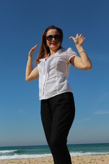 Business woman at the beach, waves her hands