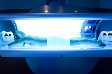 Frau im Solarium auf der Sonnenbank