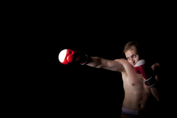 Fototapeta na wymiar Young Boxer fighter over over black background