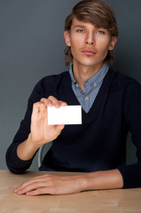 Portrait of young handsome business man holding blank white busi