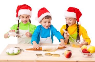 Three smiling kids with Christmas cooking