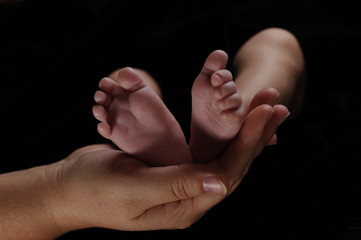 Fototapeta premium Newborn's Feet in Mother's Hand