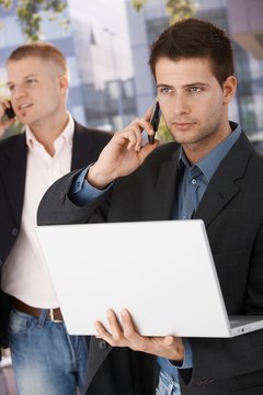 Two businessmen busy making phone call