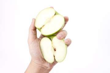 male hand holding two pieces of cut green apple.
