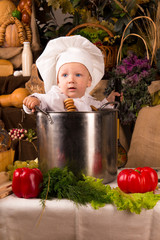 Baby wearing a chef hat sitting inside a large cooking stock pot