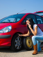 Frau mit einer Reifen Panne beim Auto