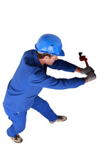 Top view of a plumber wrestling with a large wrench and pipework