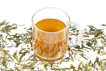 tea in glass cup and dried leaves