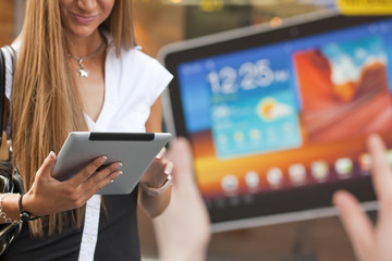 Young Woman with tablet computer walking on street