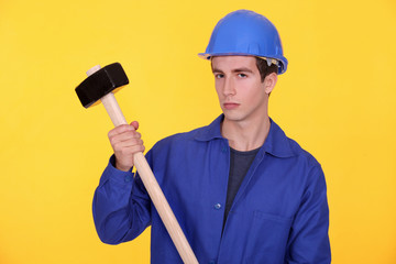 A manual worker with a sledgehammer.