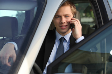 junior executive on the phone driving luxury car