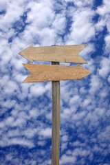 wooden sign post on blue sky