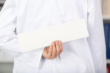 ärztin versteckt schild hinter dem rücken