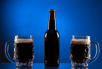 Brown beer bottle with two mugs