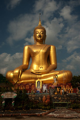 Big golden outdoor Buddha in Thai temple .