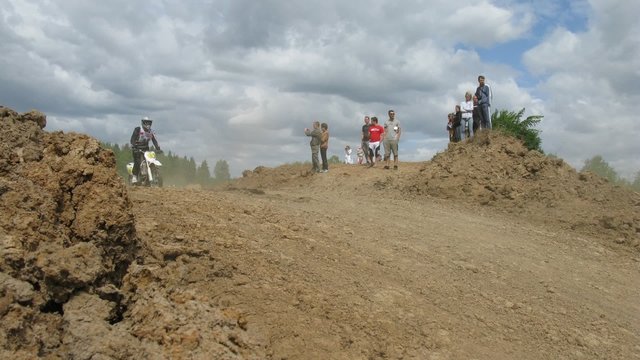 Spectators watch racers jump during enduro race