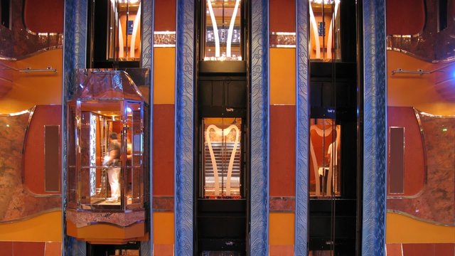 Elevators operate inside cruise liner, front view, time lapse