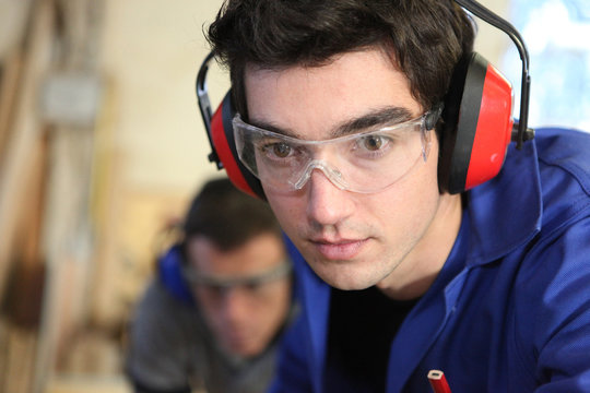 Closeup of a young worker wearing ear defenders