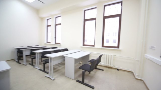 Empty classroom with wooden school desks and chairs