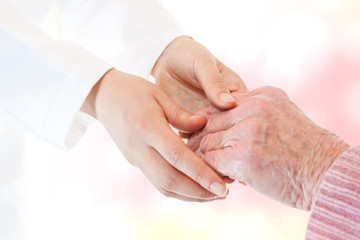Doctor holding senior lady's hand