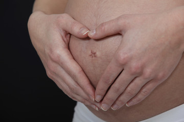 A cropped picture of a pregnant woman's belly.