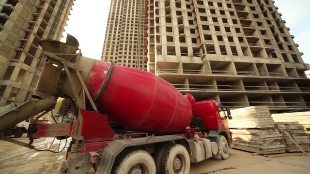 Concrete mixer stand near unfinished building