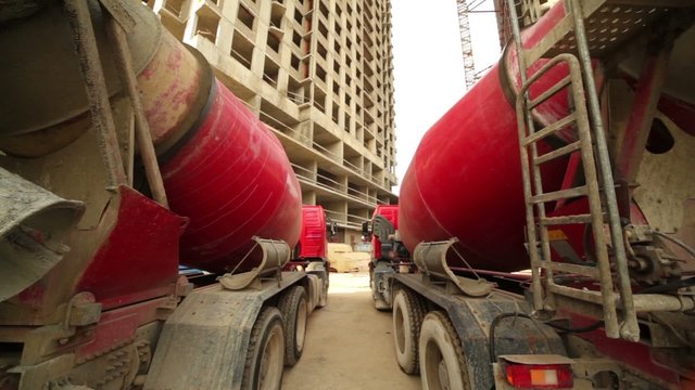 concrete mixer stand near unfinished high-rise buildings